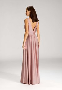 Abito lungo senza maniche in morbido tessuto rosa chiaro. Presenta una schiena profonda, vita arricciata e gonna fluente. Texture liscia, silhouette elegante.