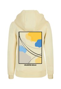 Hanorac crem cu un design grafic ce prezintă forme abstracte în nuanțe de albastru, galben și gri, conturătoare cu linii negre. Textul spune "ABILITĂȚI FĂRĂ LIMITĂ."
