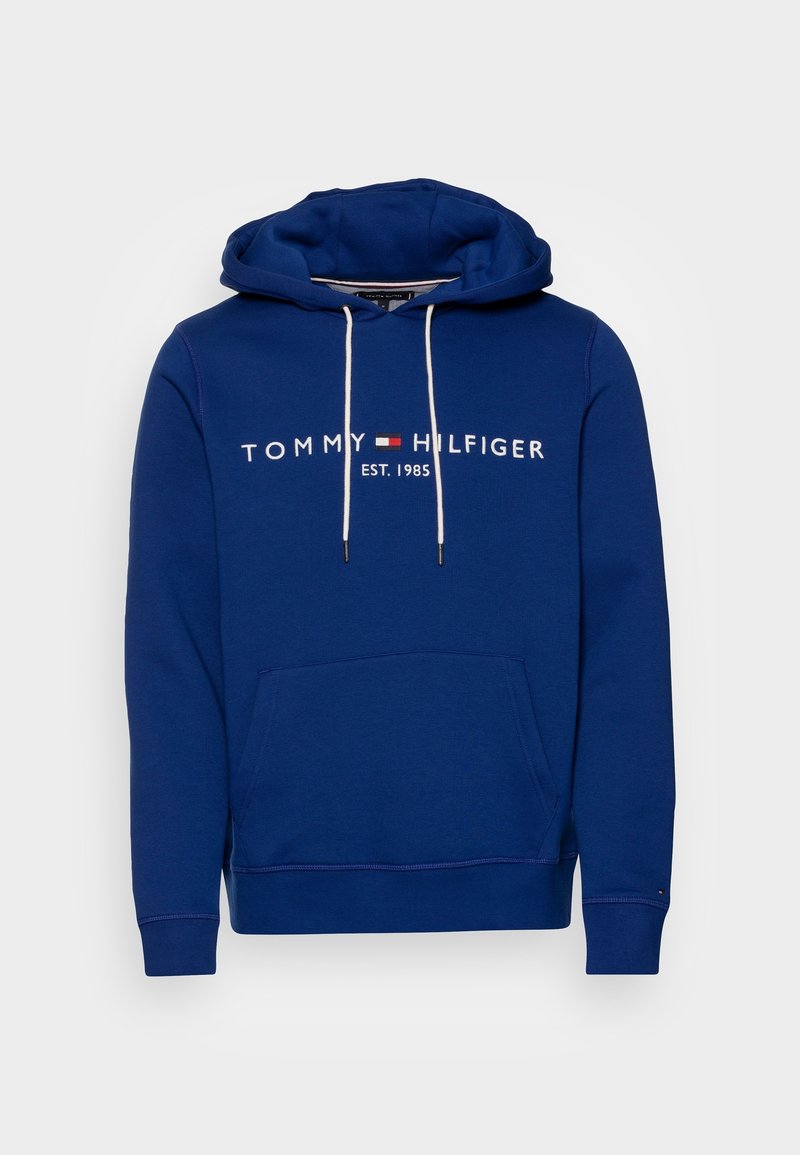 Sudadera azul con capucha, con un bolsillo frontal, cordones blancos y "TOMMY HILFIGER EST. 1985" impreso en blanco en el pecho.