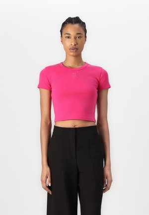 Fitted crop top in bright pink fabric with a round neckline. Features a small "HUGO" logo on the chest and short sleeves.