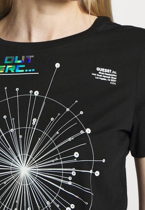 Zwart T-shirt met wit cirkelvormig abstract ontwerp, versierd met kleine glanzende studs en holografische tekst op het bovenste linkerborstgebied.