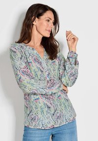 Langärmlige Bluse aus leicht grünem Stoff mit einem Paisleymuster in rosa und blauen Tönen, mit einem V-Ausschnitt und Knopfdetails.