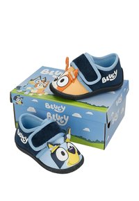 Chaussons pour enfants sur le thème de Bluey avec bandes velcro, présentant des visages de personnages en bleu et orange, exposés sur une boîte Bluey assortie.