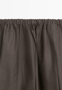 Brauner Stoff mit glatter Textur, oben mit gerafftem Gummi versehen und einem einfachen, geraden Design. Geeignet für Vorhänge oder Gardinen.