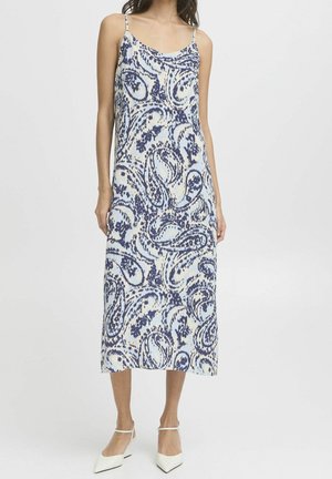 Marineblauwe en witte midilengte jurk met paisley-patroon, dunne verstelbare bandjes en een zachte stoftextuur. Platte, puntige schoenen tentoongesteld.
