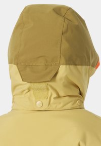 Chaqueta con capucha en un color amarillo suave y con una textura lisa. Presenta una solapa de velcro, botones a presión y un acento naranja en el borde.