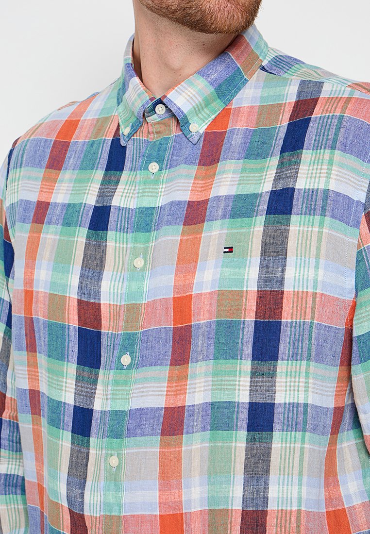 Mehrfarbiges Karomuster-Shirt mit blauen, grünen, orangen und weißen Farbtönen, mit einem Button-Down-Kragen und Logo auf der Brust. Weicher Stoff.