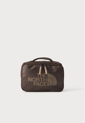 Sac rectangulaire compact marron avec poignée et fermeture éclair frontale, affichant le logo "THE NORTH FACE" en grandes lettres grasses.