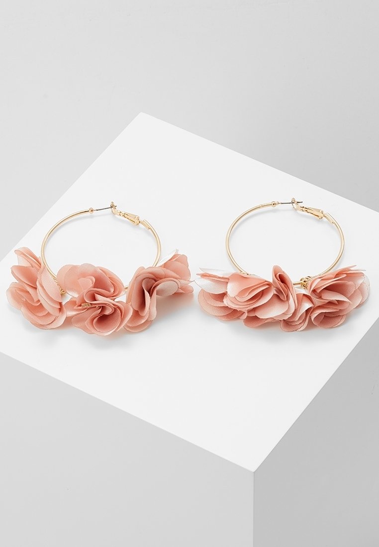 Boucles d'oreilles créoles en or ornées de plusieurs pétales de fleurs en tissu rose doux disposés sur la moitié inférieure de chaque créole.