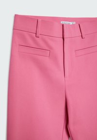 Roze op maat gemaakte broek met een gladde textuur, voorzien van twee voorzakken en een gestructureerde tailleband. Label toont de merknaam en maat.