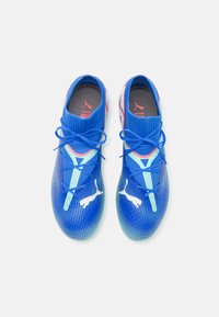 Scarpe sportive blu con tomaia in mesh, motivo testurizzato e dettagli del logo bianchi. Presentano un sistema di lacci e un interno imbottito per il comfort.
