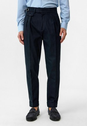 Donker marineblauwe geplooide broek met een getailleerde pasvorm, voorzien van een zijband en knoopsluiting, opgerolde cuffs en een gestructureerde stof.