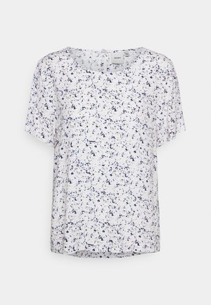 Top bianco a maniche corte con un motivo blu macchiato. Presenta un collo rotondo e una vestibilità rilassata, con una trama di tessuto leggermente trasparente.