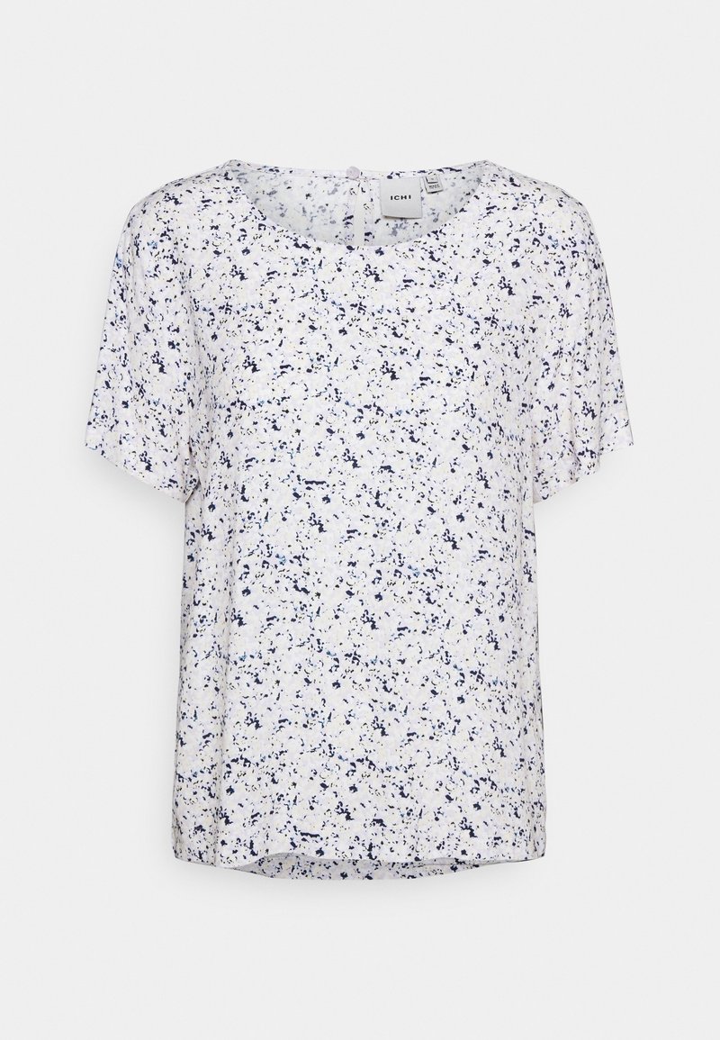 Biała bluzka z krótkim rękawem z plamkami w odcieniach niebieskiego. Ma okrągły dekolt i luźny krój, z lekko przezroczystą fakturą materiału.