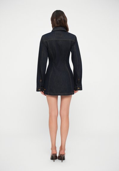 Σκούρο τζιν φόρεμα με εφαρμοστή γραμμή, μακριά μανίκια και καπιτονέ γιακά. Περιλαμβάνει ορατές ραφές και διακοσμητικά κουμπιά.