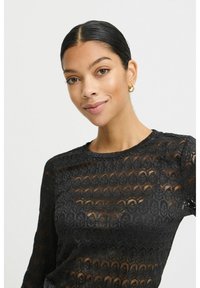 Sort blond lace langærmet top med et bladmønster, rund hals og en semi-gennemsigtig tekstur, som fremhæver de intrikate detaljer gennem hele designet.