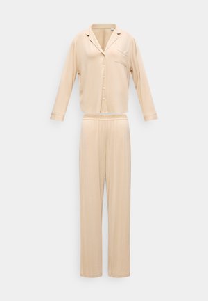 Beige long-sleeve button-up pajama top with collar and chest pocket, paired with matching loose-fitting elastic waist pants.