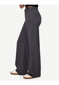 Gray wide-leg trousers with a textured finish, featuring a high waist and button closure. Worn with light-colored shoes.