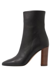 Black leather ankle boot with a smooth texture, pointed toe, and a wooden block heel, featuring a high shaft design.