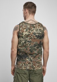 Zöld, barna és fekete mintázatú terepmintás ujjatlan top; kerek nyakkivágással készült; az anyag könnyűnek és puhának tűnik.