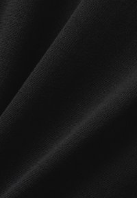 Tissu noir, présentant une texture lisse avec une finition mate, comportant des coutures et des plis subtils, indiquant un design drapé.