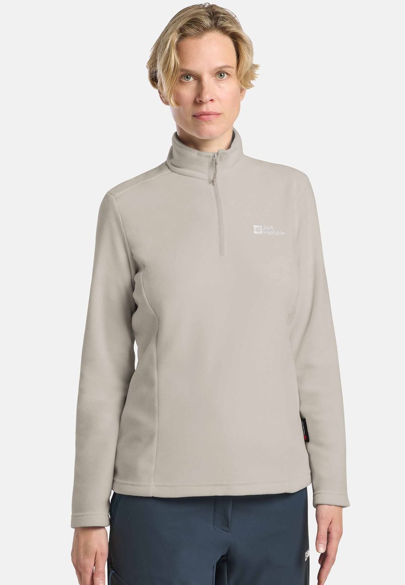 Pullover in pile grigio chiaro con colletto con zip, maniche lunghe e un logo sul petto. Il materiale sembra morbido e ha una texture liscia.