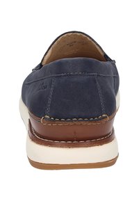 Marineblauwe leren instappers met een ronde neuzen, witte rubberen zool en bruin leren accenten. Gestikte details langs de randen.