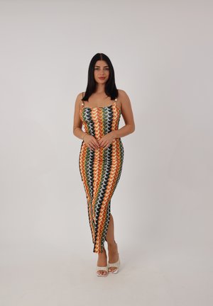Mehrfarbiges Strickkleid mit einem Zickzackmuster in grün, orange und gelben Farbtönen. Figurbetonte Silhouette mit Spaghetti-Trägern und seitlichem Schlitz.
