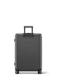 Hartschalenkoffer in Schwarz mit horizontalen Rillen, ausziehbarem Griff und vier Rollen für Mobilität. Kompaktes Design und glatte Oberfläche.