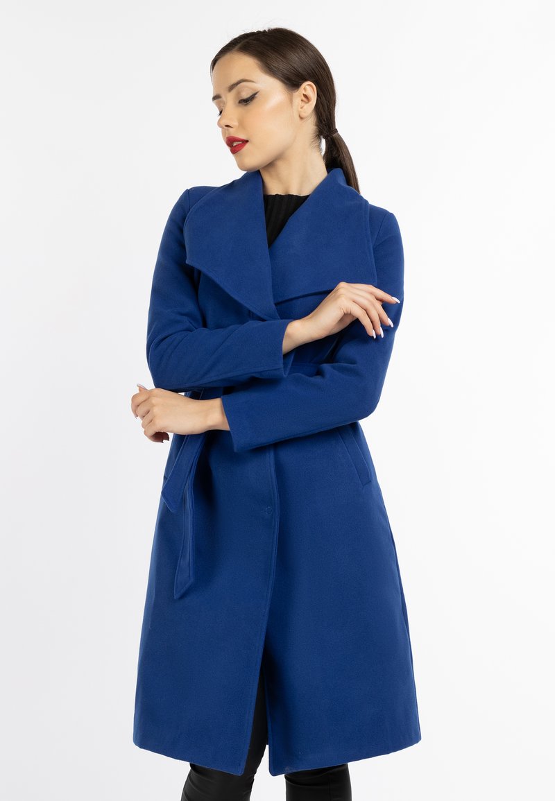 Palton albastru, până la genunchi, cu guler larg, mâneci lungi și cordon legat în talie. Fabricat dintr-un material neted, dispune de buzunare laterale și un design simplu.