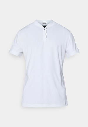 Valge lühikeste varrukatega polo särk, millel on püsti kaelus, tõmblukuga kaelus ja diskreetne brändingu detail tõmbluku ääres. Sile ja kerge kangas.