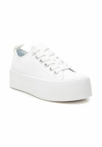 Zapatillas de plataforma de lona blanca con punta redonda, cordones en la parte frontal y accesorios en plateado. Suela texturizada con líneas horizontales, interior suave.
