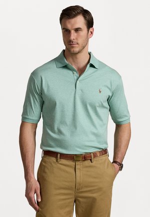 Lichtgroene poloshirt met korte mouwen, gekraagd ontwerp, met een klein geborduurd logo op de borst. Gekoppeld met kaki broek.