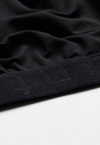 Sort stof med en glat tekstur, der har et bredt bærestykke med præget 'ULT' bogstaver. Designet er funktionelt og minimalistisk.