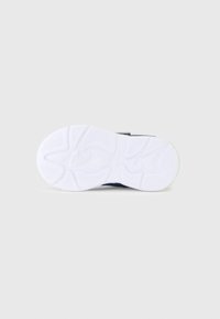 Σόλα αθλητικού παπουτσιού με λευκό καουτσούκ υλικό και υφή στην επιφάνεια, σχεδιασμένη με κυματιστά σχέδια και ένα μικρό πράσινο διακοσμητικό.