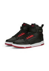 Black high-top sneakers with red accents, leather and synthetic materials, textured side panels, white midsole, and strap closure.