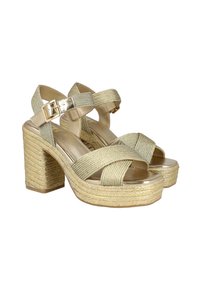 Sandalias de tacón alto en oro y beige con plataforma de cuerda trenzada y acentos metálicos, que presentan un cierre de hebilla y tiras cruzadas.