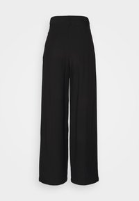 Pantalons larges noirs avec une texture lisse et un design taille haute. Présente une taille sans coutures et aucun ornement visible.