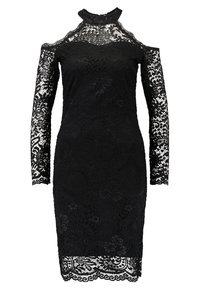 Robe noire en dentelle longueur genou avec découpes aux épaules, manches longues en dentelle transparente et col montant à bords festonnés.