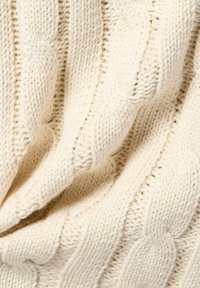 Sweter w odcieniu kremowym z dzianiny o splocie warkoczowym, charakteryzujący się teksturowanym wzorem z skręconymi kablami oraz miękkim, grubym splotem.