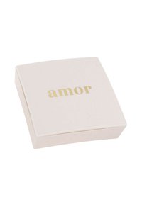 Confezione compatta e quadrata di colore rosa pallido con finitura liscia; presenta la parola "amor" in carattere dorato sulla parte superiore.