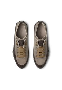 Sneakers in suede beige con accenti marroni. Presentano lacci tondi e suole testurizzate. Superfici lisce con logo sulla linguetta. Design classico con allacciatura.