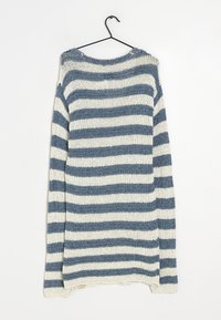Maglione a maniche lunghe a righe blu e bianche appeso a una gruccia nera su uno sfondo bianco.