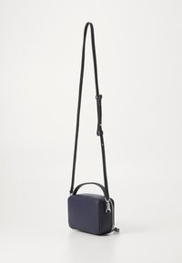 Geantă crossbody rectangulară de culoare bleu marin, confecționată din piele netedă, cu un mâner superior, curea ajustabilă și detalii cu fermoar argintiu.