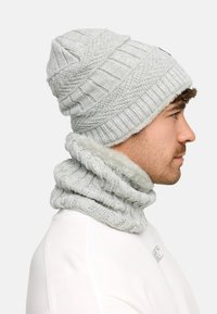 Light gray knit beanie with textured patterns and a fluffy lining, paired with a matching ribbed cowl featuring a soft inner material.