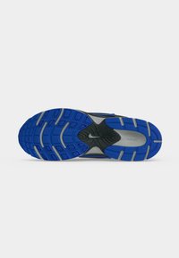 Σόλα μαύρου και γκρι αθλητικού παπουτσιού Nike με μπλε και γκρι πέλμα, με το λογότυπο της Nike στην κεντρική περιοχή και στην περιοχή της φτέρνας.