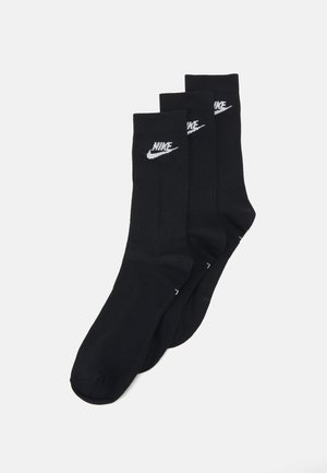 Tři páry černých bavlněných ponožek s bílým logem Nike, s žebrovanou texturou a designem v délce po kotník.