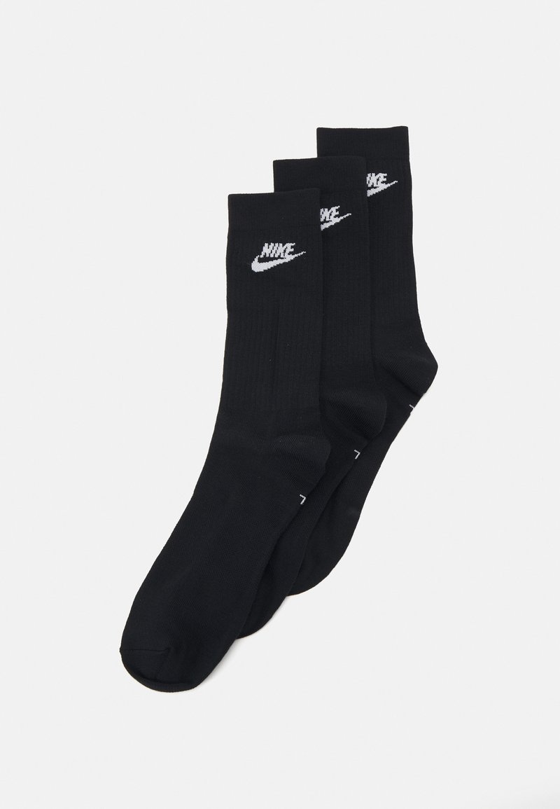 Tri parov črnih bombažnih nogavic z belim Nike logotipom na vsaki, rebrast tekstura in oblikovanje do gležnjev.