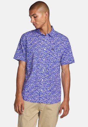Short-sleeve button-up shirt in vibrant purple with a white rose pattern. Made of lightweight fabric with a collar and front pocket detail.