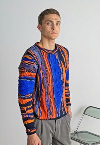Strickpullover mit einem strukturierten Muster aus blauen, orangefarbenen und lila vertikalen Streifen sowie einem kontrastierenden gerippten Rundhalsausschnitt und Bündchen.